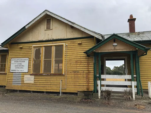 Nyora’s yellow weatherboard station, photographed in January 2023. Heritage context; not a report of current access or building condition.