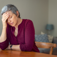 a woman with her hand to her forehead, frustrated