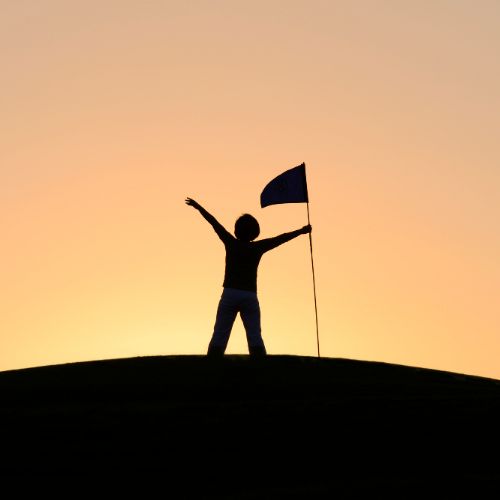 person in the distance standing near a flag