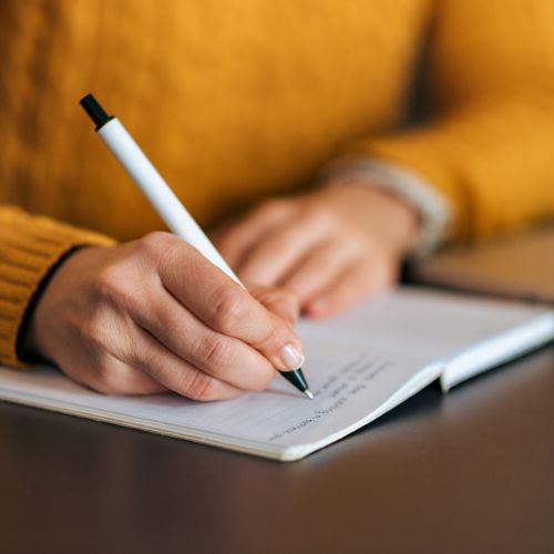 person writing in a notebook