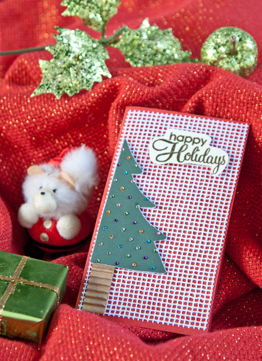 Artesã compõe cartão de Natal de scrapbooking