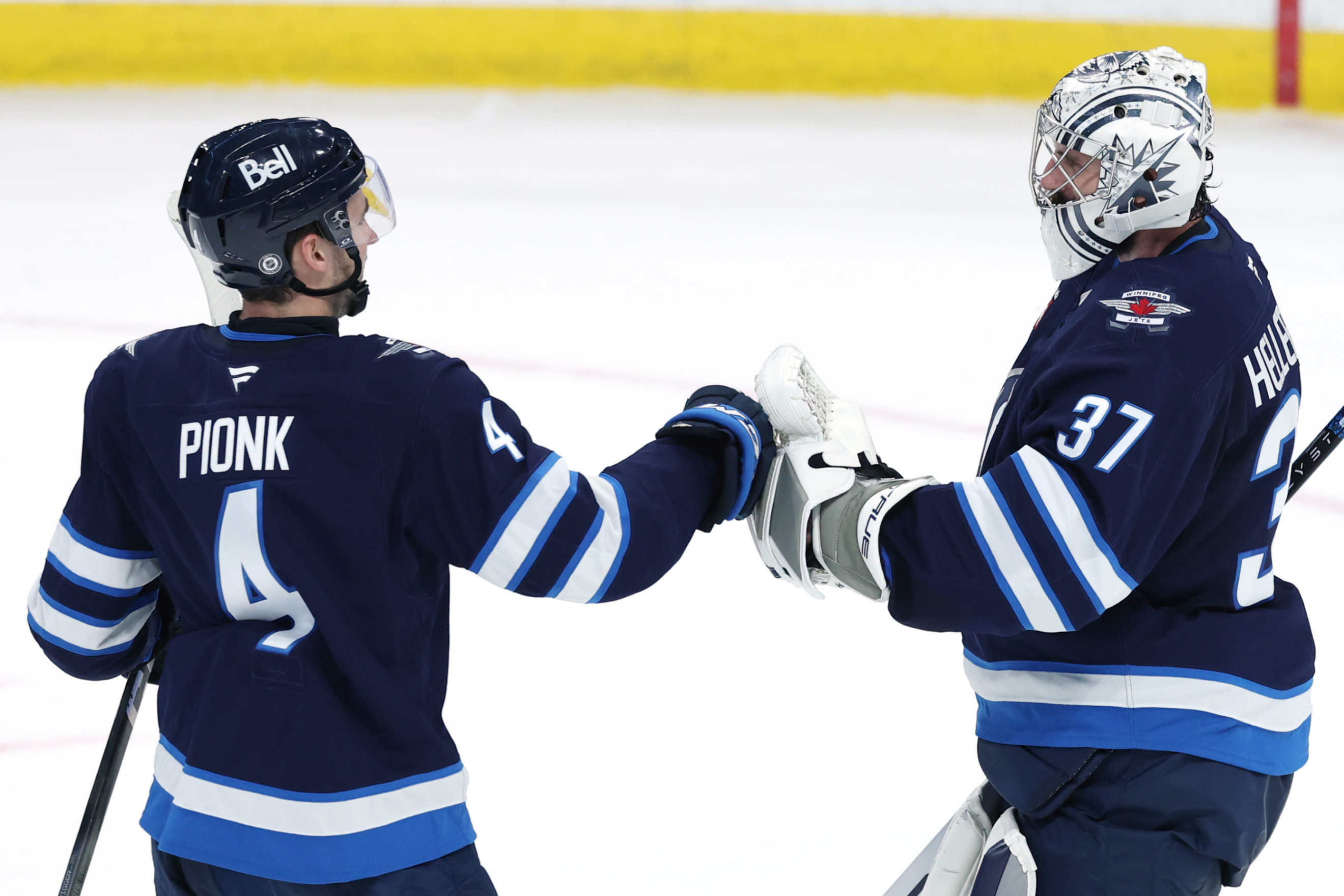 Neal Pionk and Connor Hellebuyck (James Carey Lauder-Imagn Images)