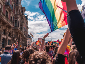 a crowd of people holding a rainbow flag