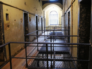 A long hallway with metal railings leading to a window
