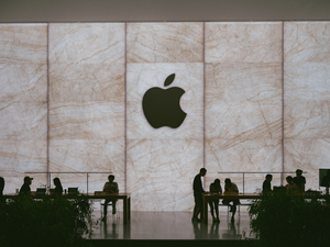 a group of people standing in front of an apple logo
