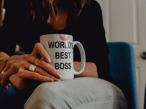 Woman's hand holding "World's Best Boss" mug