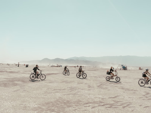 a group of people riding bikes across a desert