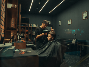 a man cutting another mans hair in a barber shop