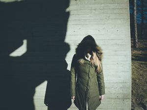 a woman standing in front of a shadow of a building