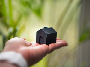 real estate agent hold home miniature house handover green plant background
