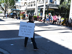 Naples, Florida, USA-January 16, 2023: A woman with a LGBTQ sign at the Martin Luther King, Jr. Parade. Editorial use only.