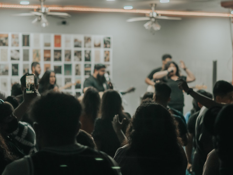 man in black shirt singing on stage