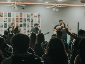 man in black shirt singing on stage