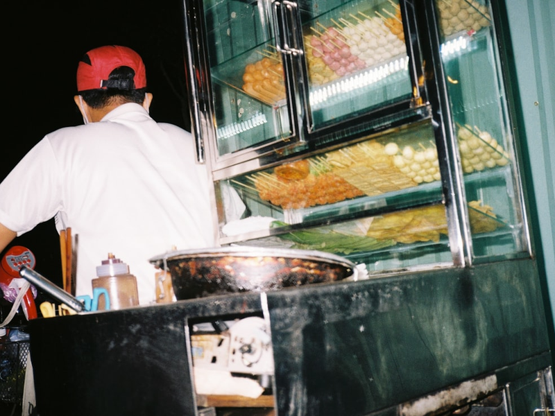 man in white shirt standing near food display counter