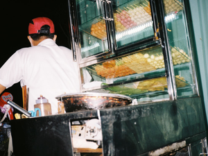 man in white shirt standing near food display counter