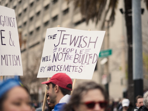 People hold up signs stating "I STAND AGAINST HATE & ANTISEMITISM" AND "THE JEWISH PEOPLE WILL NOT BE BULLIED BY ANTISEMITES" at the Unity Rally, a march against antisemitism in San Francisco.