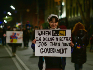 a woman holding a sign that says when it's doing a better job than