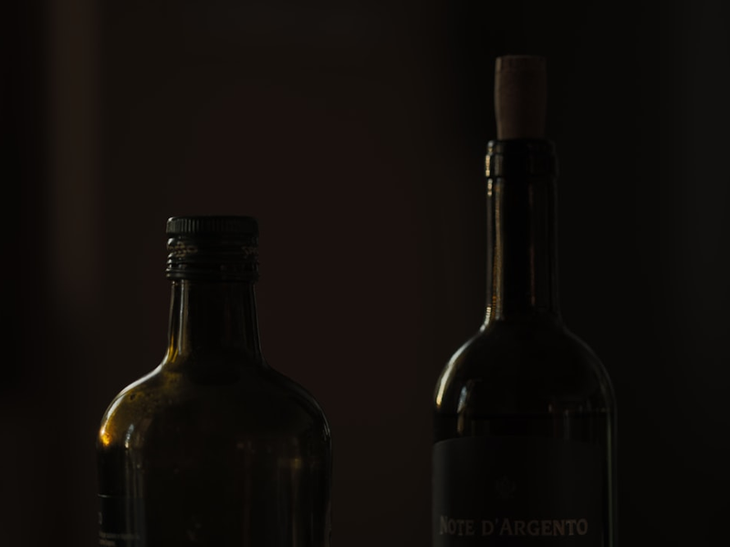 two black glass bottles on black surface