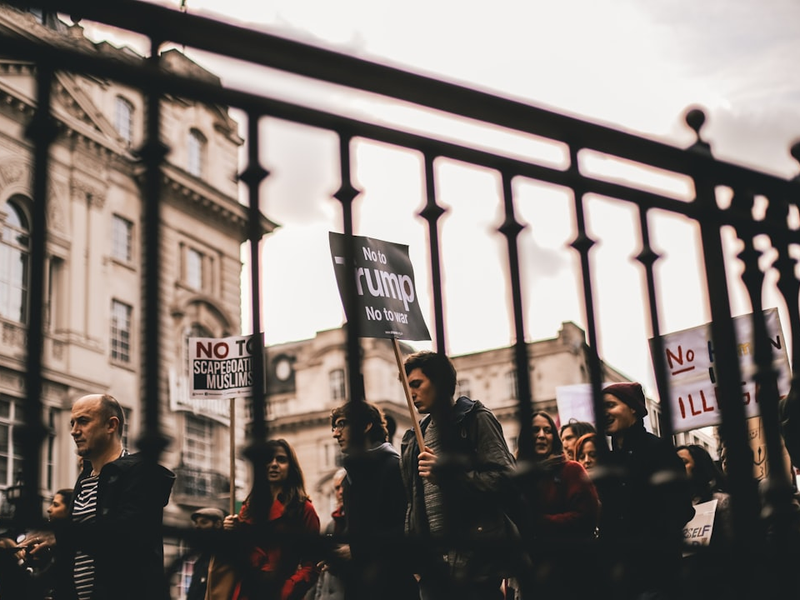 people walking with signs at the city during day