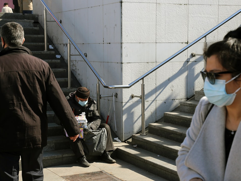 man in black jacket and gray pants walking on gray concrete stairs