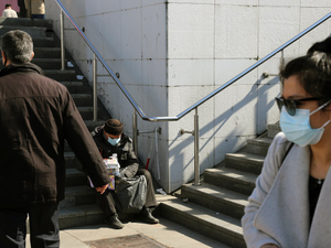 man in black jacket and gray pants walking on gray concrete stairs