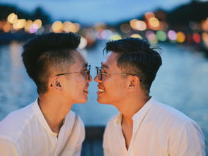 Two men share a loving moment, nose to nose.