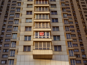 a tall building with windows and a red stop sign