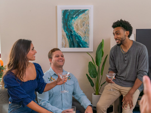 Joyful Group Gathering by the Sable Flow Art Frame Whiteboard. A lively group shares wine, laughter, and conversation against the of Sable Flow's art frame whiteboard, creating a vibrant and engaging atmosphere