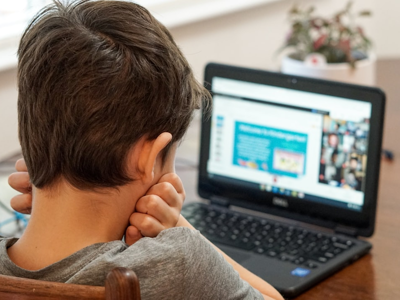 Kindergarten boy looking at laptop computer during first day of virtual learning online school.