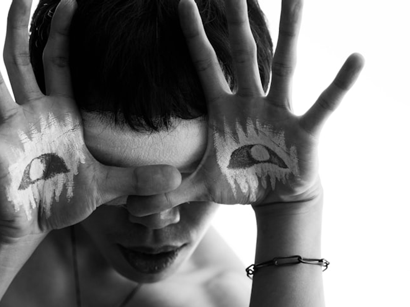a woman with painted hands covering her face