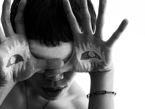 a woman with painted hands covering her face