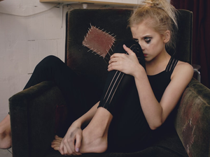Young teenage girl actress with smudged makeup crying after loss film casting sits in chair in studio