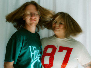 Two people toss their hair playfully in a photo.