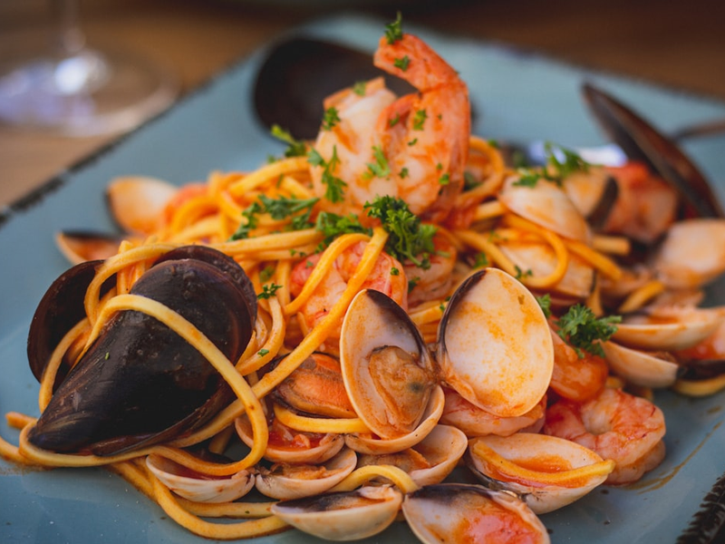 a plate of pasta with clams and shrimp