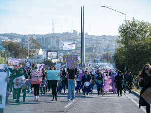 a group of people walking down a street holding signs