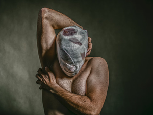 topless man covered face with white bandage