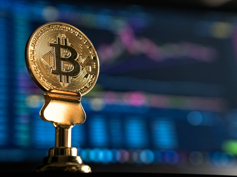 selective focus photo of Bitcoin near monitor