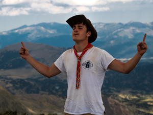 man in white t-shirt wearing scarf and black hat