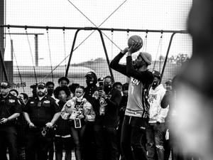 a man holding a basketball in front of a group of people