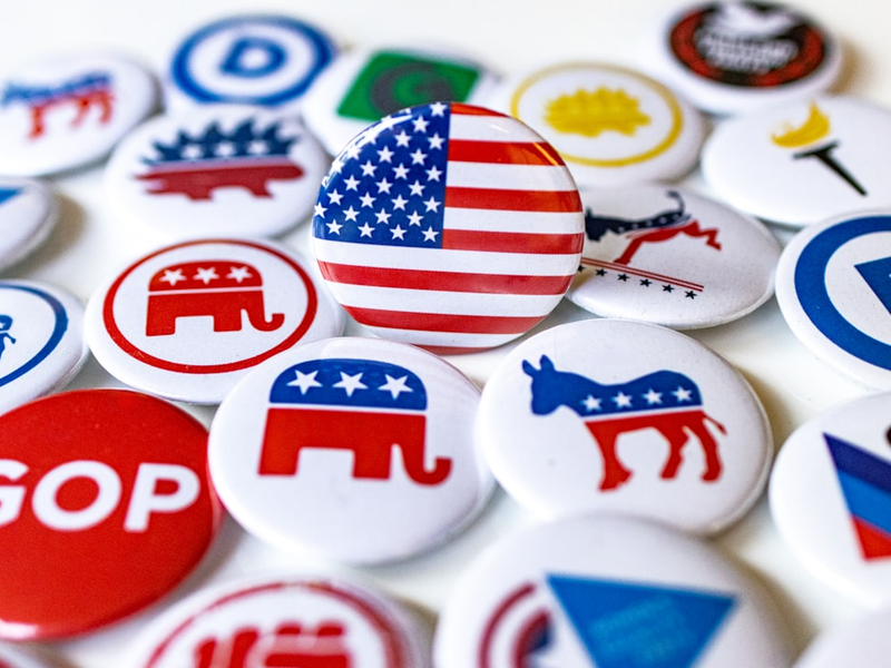 A pile of political buttons sitting on top of a table