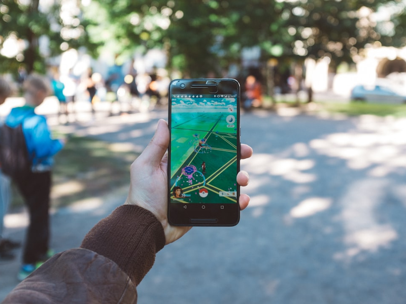 person playing Pokemon Go during daytime