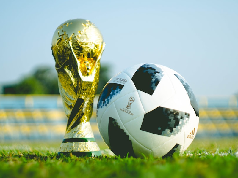 gold-colored trophy and soccerball