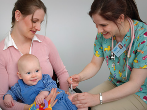 A paediatrician giving a baby a vaccine injection