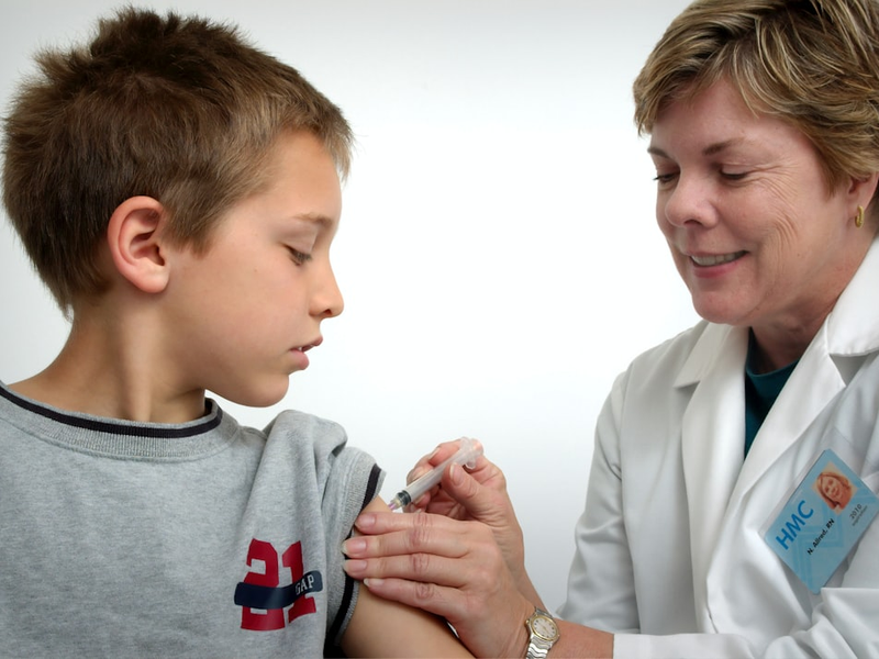 woman inject boy on arm