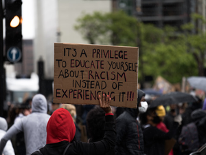 people holding brown wooden signage during daytime