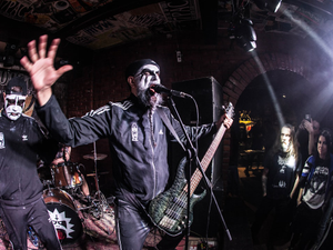 A band performs on stage with intense energy.