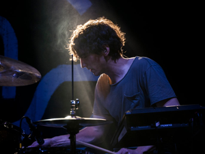 a man playing drums in front of a microphone