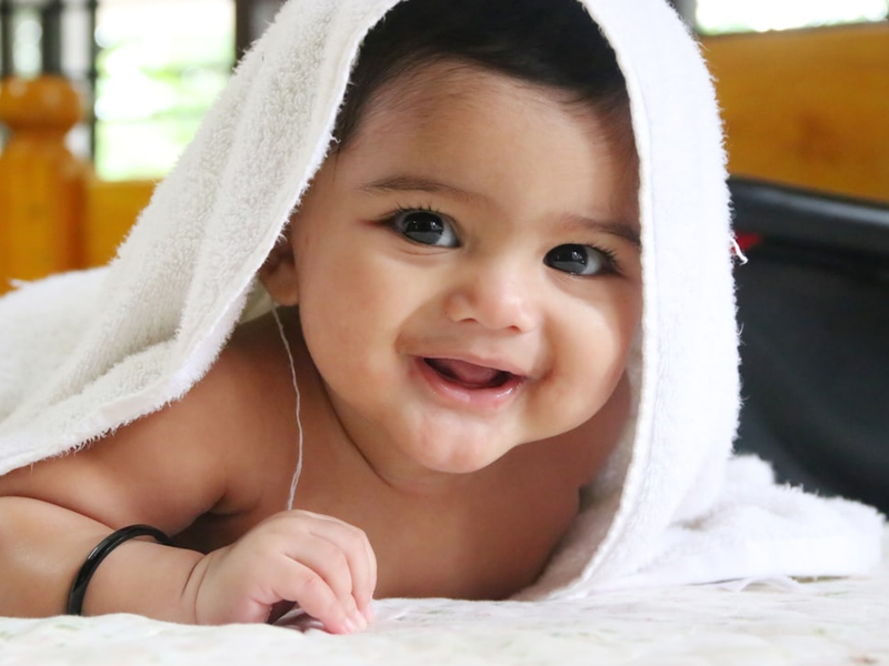 Cute happy baby girl smiling in white bath towel