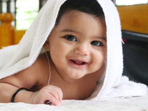 Cute happy baby girl smiling in white bath towel