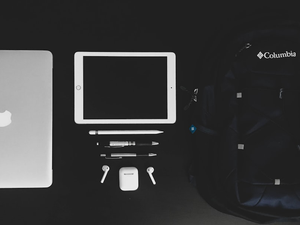 MacBook Air and white iPad near black Columbia backpack